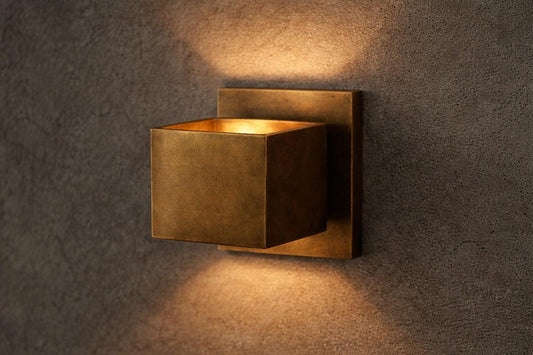 Square brass wall sconce casting light up and down the wall