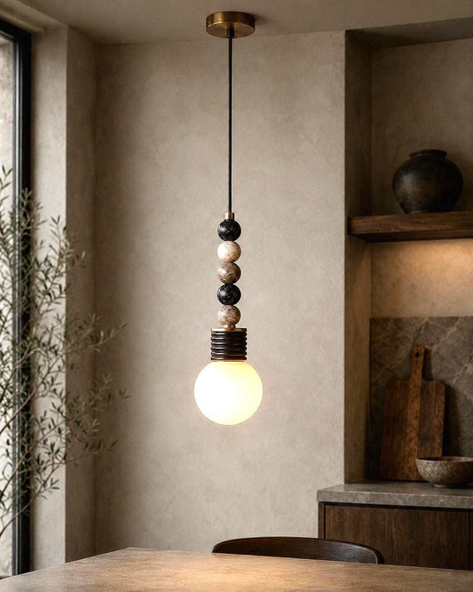 Marble sphere pendant light with frosted glass globe above a dining table