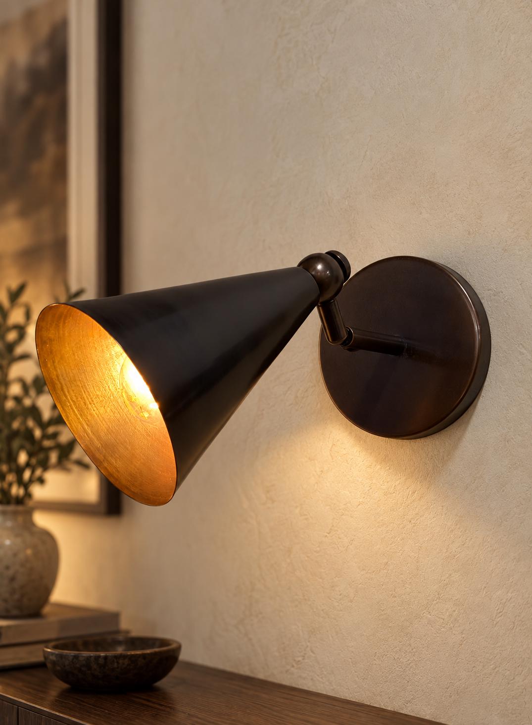 Dark bronze cone sconce with gold interior and swivel arm